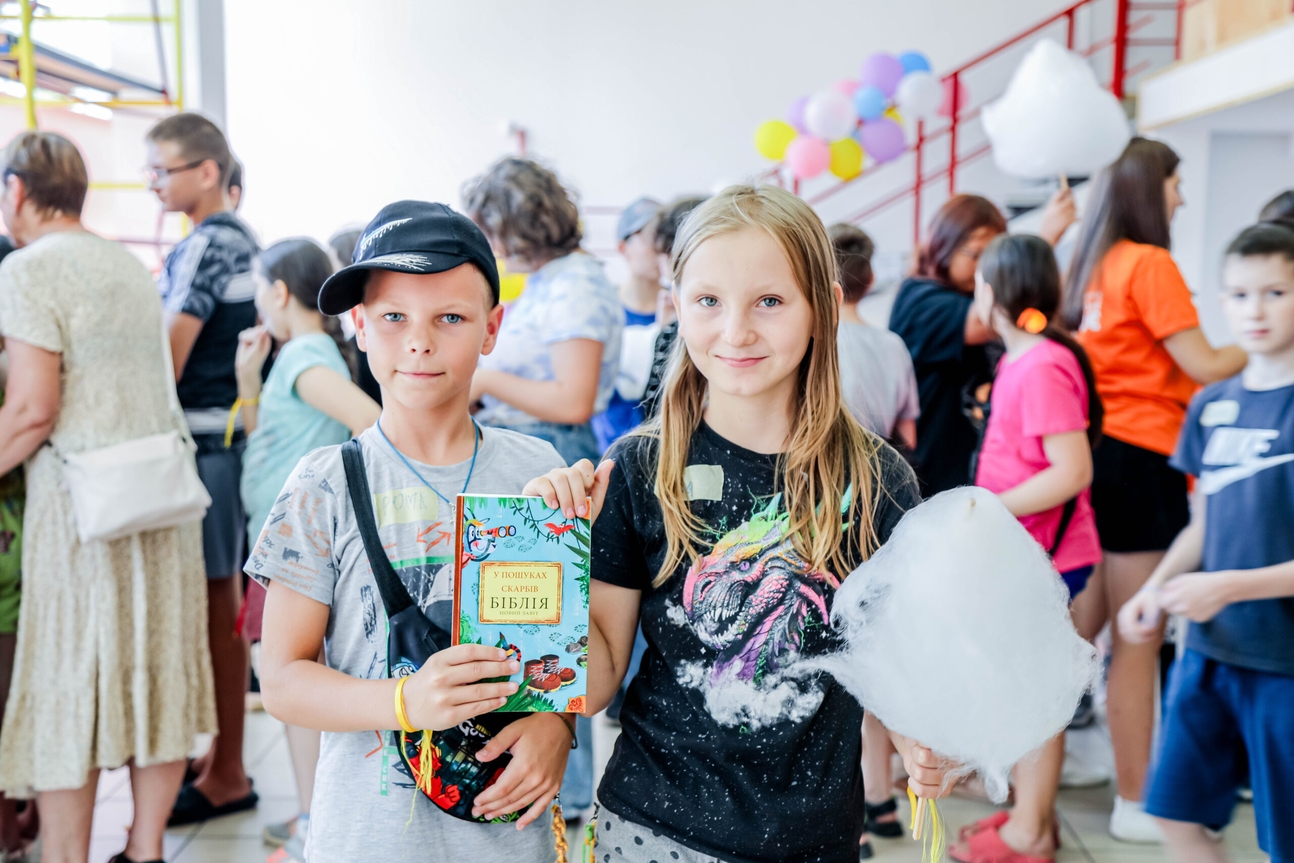 boy and girl smiling and holding bible at summer bible camp